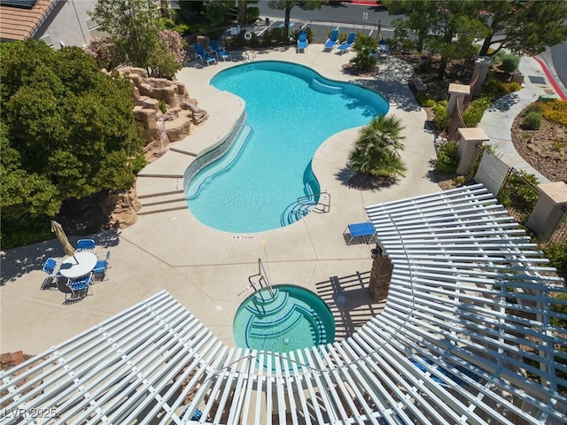 community pool with a patio and fence