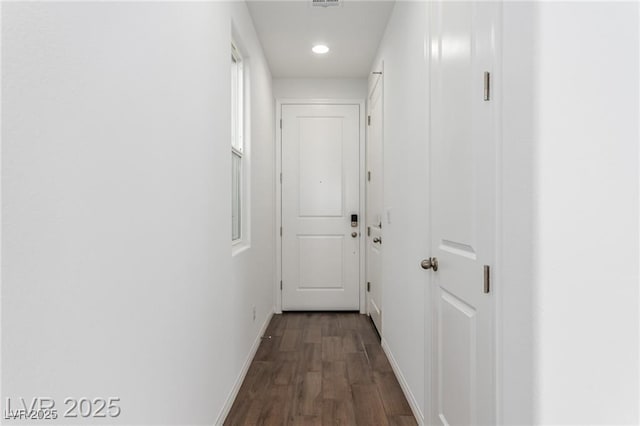 hallway with visible vents, baseboards, recessed lighting, and dark wood finished floors