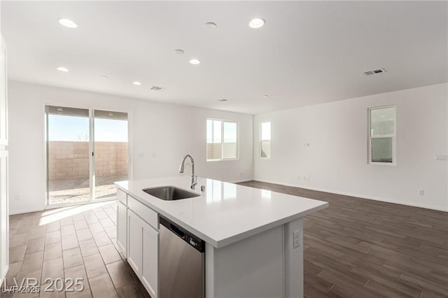 kitchen featuring dark wood-type flooring, visible vents, a healthy amount of sunlight, stainless steel dishwasher, and a sink