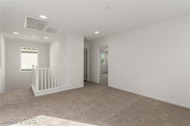 spare room with visible vents, recessed lighting, and carpet flooring