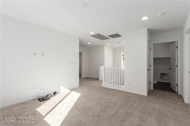 spare room featuring visible vents, recessed lighting, and light colored carpet