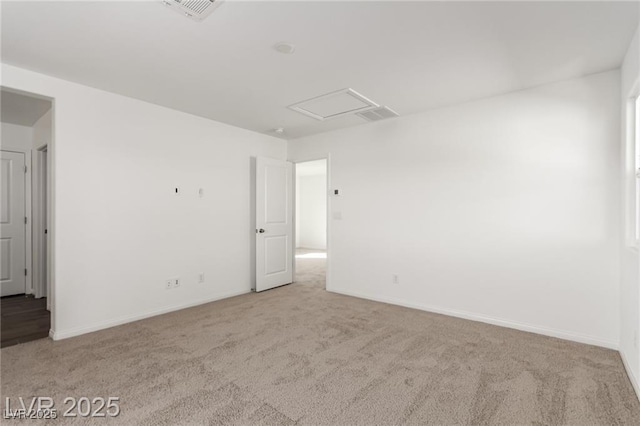 carpeted spare room with visible vents and baseboards