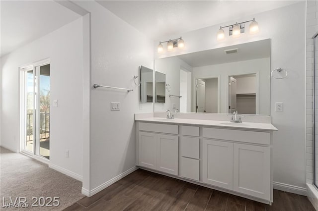 bathroom featuring wood finished floors, a sink, and double vanity
