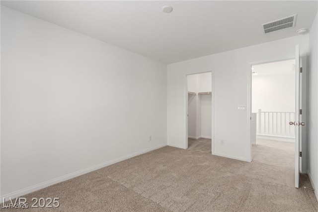 unfurnished bedroom with carpet flooring, baseboards, visible vents, a spacious closet, and a closet