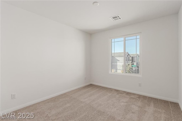empty room with baseboards, visible vents, and carpet floors