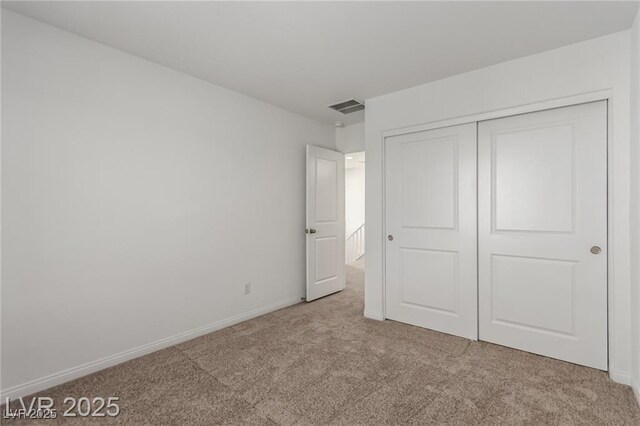 unfurnished bedroom featuring baseboards, visible vents, carpet floors, and a closet