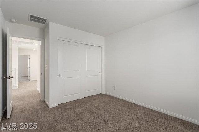 unfurnished bedroom with visible vents, baseboards, carpet flooring, and a closet