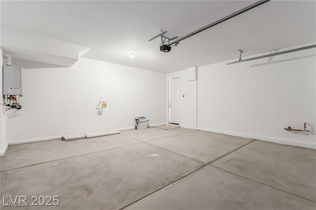garage featuring a garage door opener, tankless water heater, and baseboards