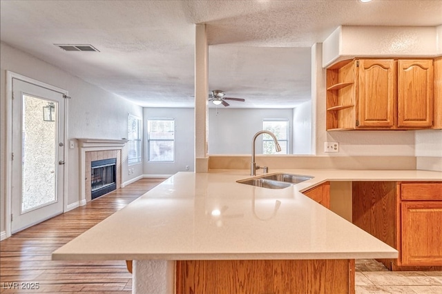 kitchen with light countertops, a peninsula, a sink, and visible vents