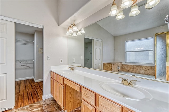 full bathroom featuring a sink, double vanity, and a notable chandelier