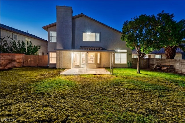 back of house with a patio area, a fenced backyard, a lawn, and stucco siding