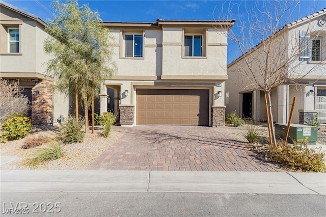 view of front of home featuring a garage, stone siding, stucco siding, and decorative driveway