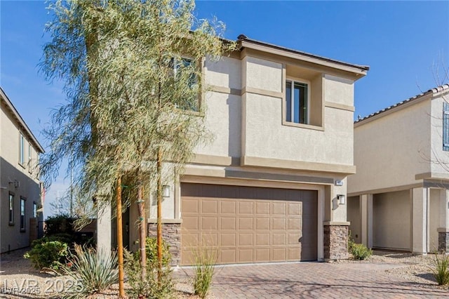 view of front of house featuring stone siding, stucco siding, decorative driveway, and a garage