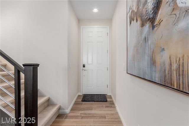 doorway featuring recessed lighting, baseboards, wood finished floors, and stairs