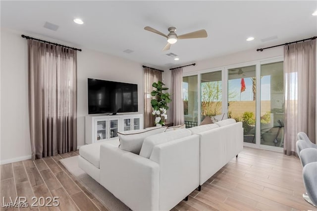 living room featuring recessed lighting, a ceiling fan, visible vents, and light wood-type flooring
