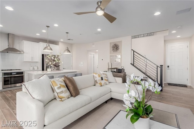 living room featuring recessed lighting, light wood-style flooring, and ceiling fan