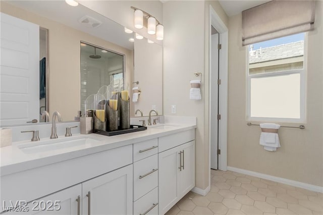 bathroom with double vanity, tile patterned flooring, a shower, and a sink
