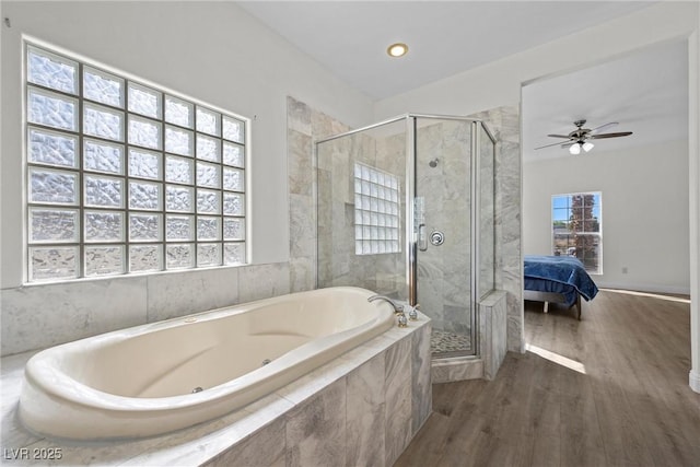 ensuite bathroom with a shower stall, wood finished floors, ensuite bath, and a garden tub