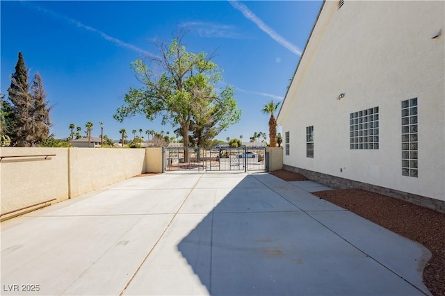 view of patio with fence and a gate