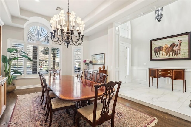 2338 Dolphin Ct, Henderson, NV 89074 - dining room with a chandelier, plenty of natural light, wainscoting, dark wood-style floors, and a towering ceiling