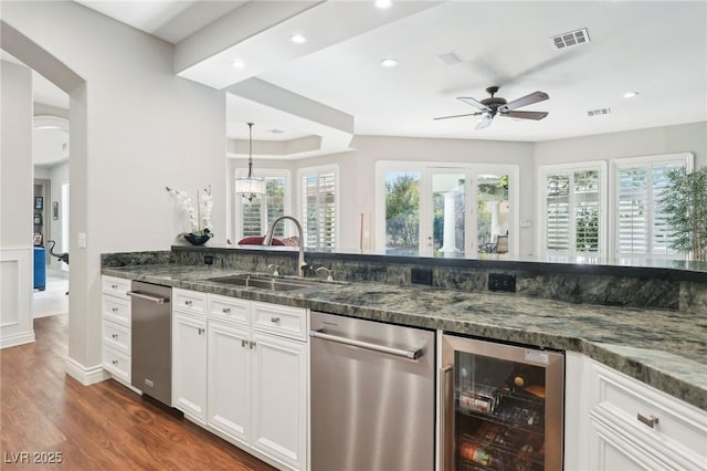 2338 Dolphin Ct, Henderson, NV 89074 - kitchen with wine cooler, a sink, stainless steel dishwasher, a ceiling fan, and dark wood-type flooring