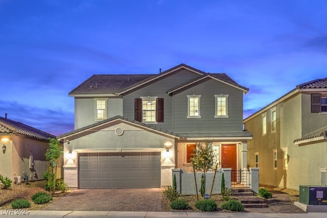 traditional-style home with a garage and decorative driveway