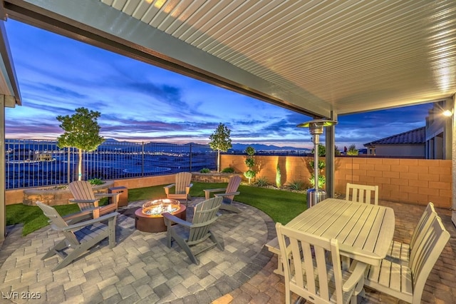 view of patio featuring outdoor dining space, a fire pit, and fence