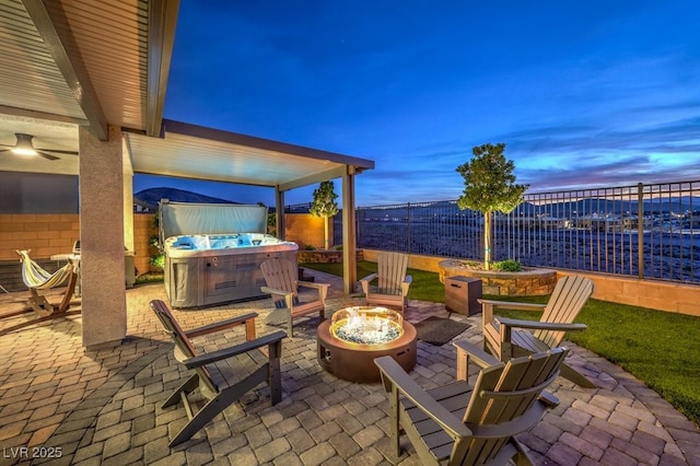 patio terrace at dusk with an outdoor fire pit and a fenced backyard