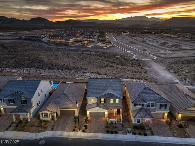 aerial view at dusk featuring a residential view and a mountain view
