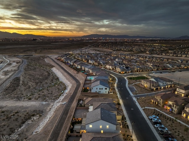 aerial view at dusk featuring a residential view and a mountain view