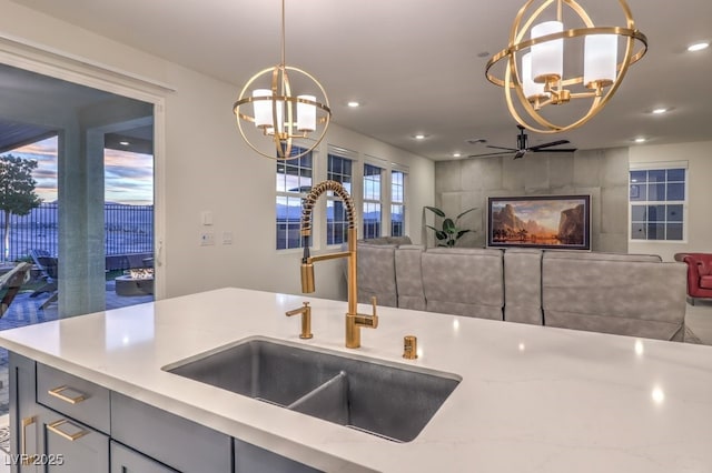 kitchen with open floor plan, a sink, recessed lighting, and hanging light fixtures