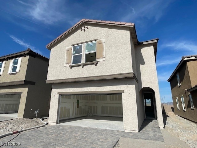 9556 Hinson St, Las Vegas, NV 89139 - view of front facade with stucco siding, a garage, and decorative driveway