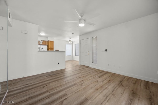 3425 E Russell Rd Unit 155, Las Vegas, NV 89120 - unfurnished living room with ceiling fan, baseboards, and light wood finished floors