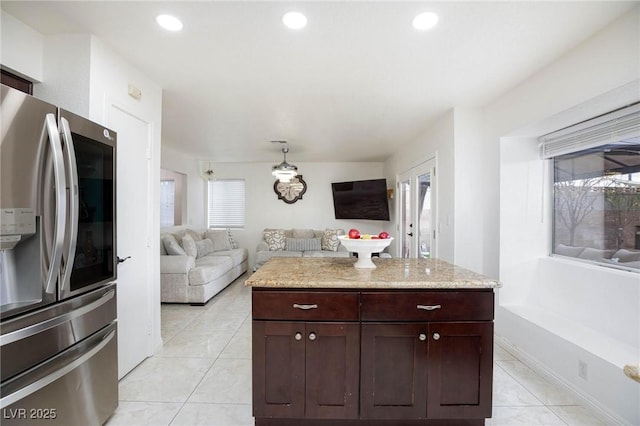kitchen featuring stainless steel fridge, open floor plan, recessed lighting, light stone countertops, and light tile patterned flooring
