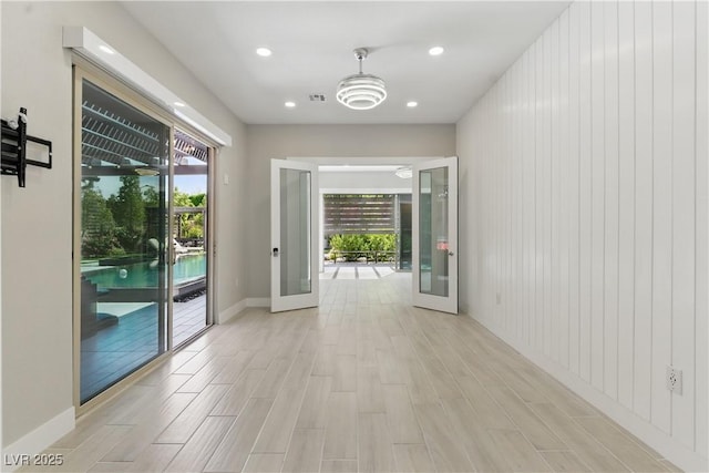 doorway with light wood-style floors, recessed lighting, baseboards, and a wealth of natural light