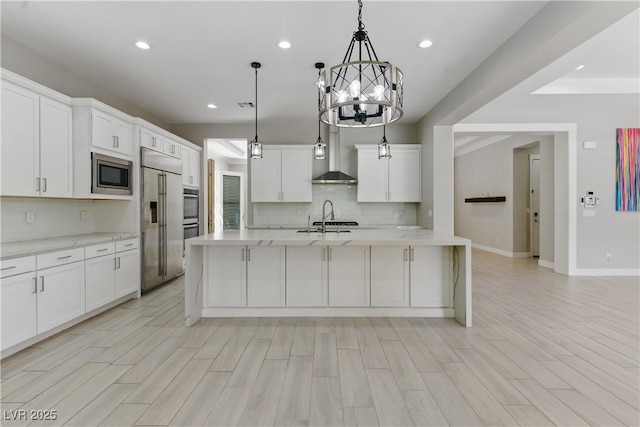 kitchen with an inviting chandelier, built in appliances, wall chimney exhaust hood, recessed lighting, and backsplash