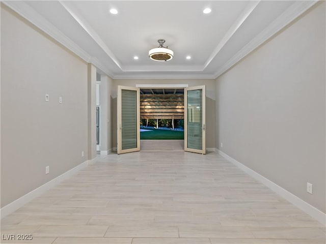 hallway featuring recessed lighting, ornamental molding, a raised ceiling, and baseboards