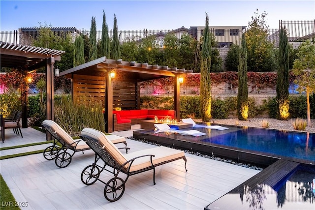 pool with a pergola, fence, a patio area, and an outdoor living space with a fire pit