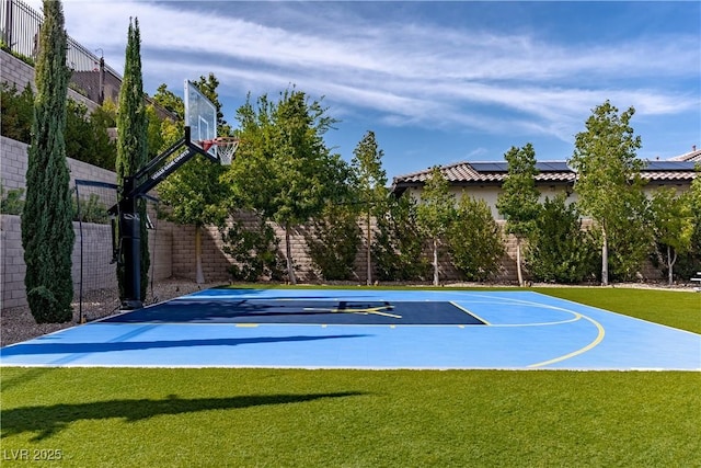 view of sport court featuring basketball court, a lawn, and fence