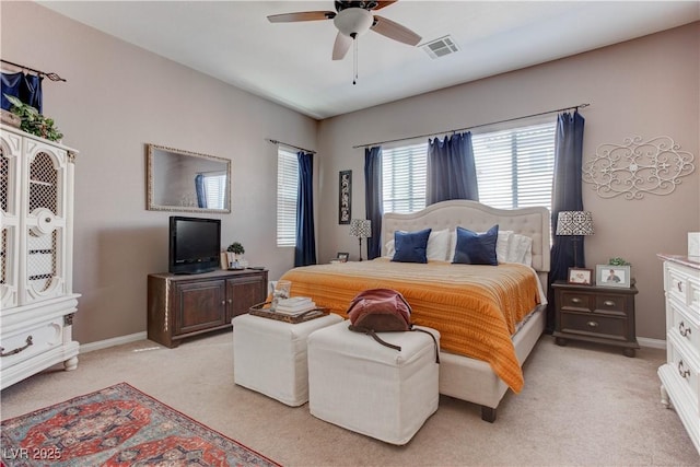 bedroom featuring a ceiling fan, visible vents, light carpet, and baseboards