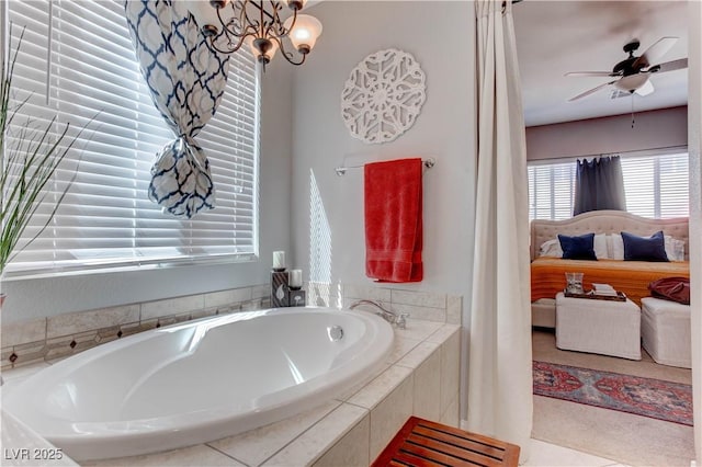 bathroom featuring a garden tub and ceiling fan with notable chandelier