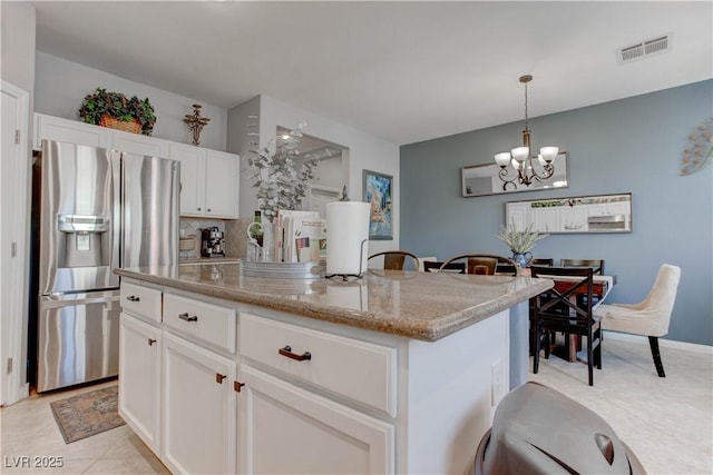 kitchen featuring white cabinets, visible vents, a kitchen island, an inviting chandelier, and stainless steel fridge with ice dispenser