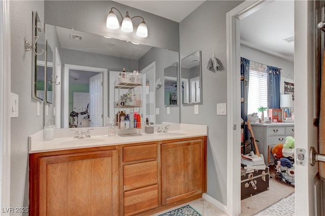 bathroom featuring baseboards, visible vents, double vanity, and a sink