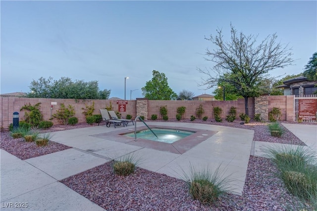view of pool featuring a fenced backyard, a patio, and a hot tub