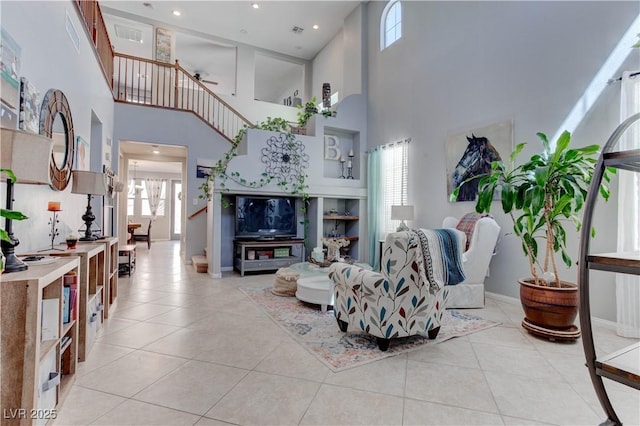 living room with baseboards, light tile patterned floors, and a high ceiling