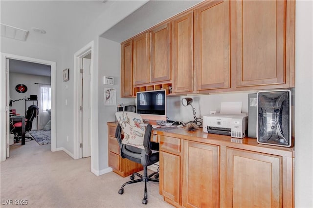 office area featuring baseboards, visible vents, light colored carpet, and built in desk