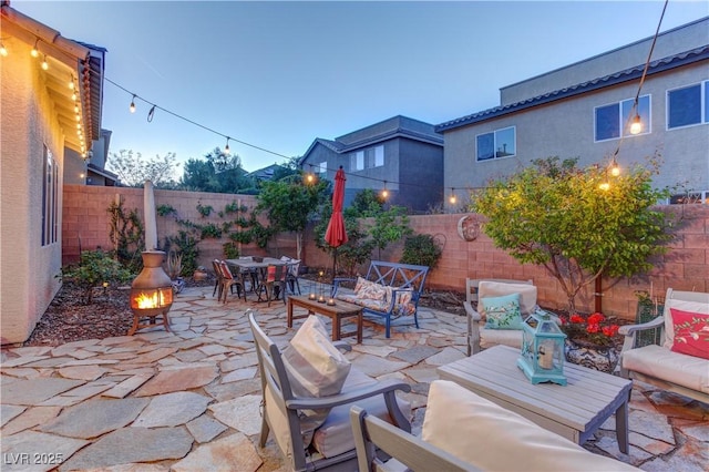 view of patio with a fenced backyard and an outdoor living space with a fire pit