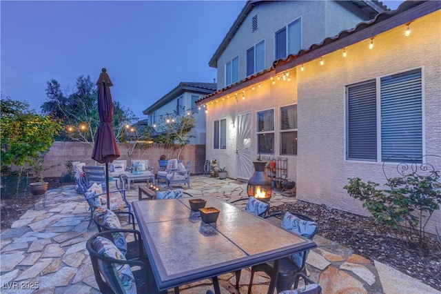 view of patio / terrace with a fire pit, fence, and outdoor dining area