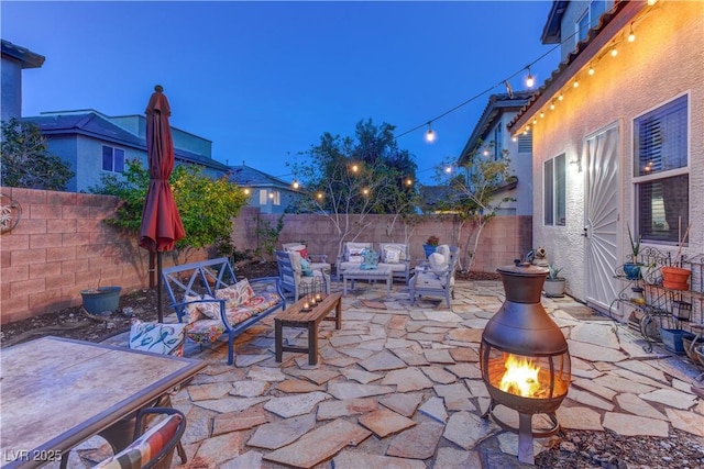 view of patio / terrace with an outdoor living space with a fire pit and a fenced backyard