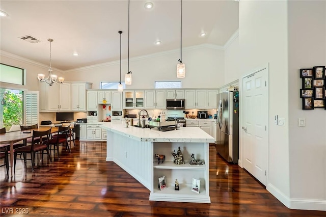 521 Dawn Cove Dr, Henderson, NV 89052 - kitchen with appliances with stainless steel finishes, high vaulted ceiling, crown molding, white cabinetry, and pendant lighting